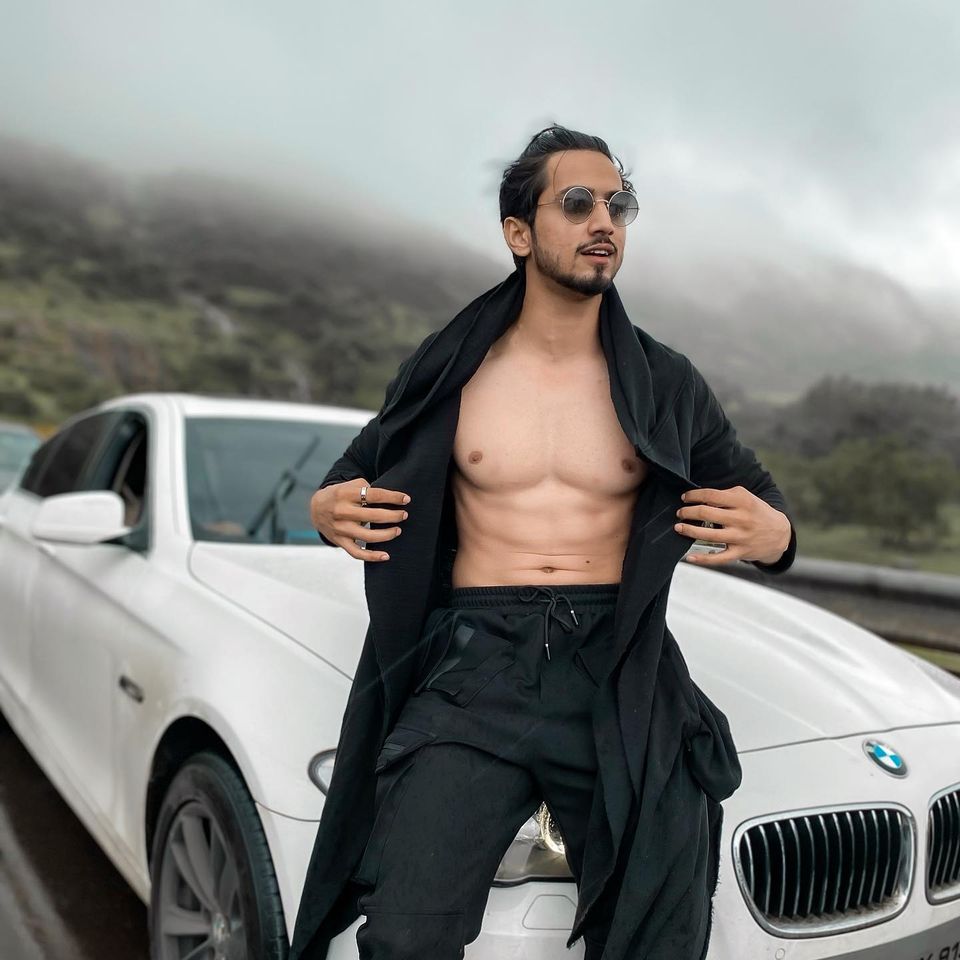 Faisal posing with his BMW